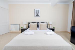 un grande letto bianco con due asciugamani bianchi sopra di Appartement Luxueux à Hydra a Hydra