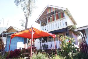 ein Haus mit einem Regenschirm davor in der Unterkunft Collection O 93000 Karona Berg Homestay & Cafe in Banyuwangi