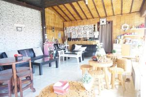 ein Zimmer mit Tischen und Stühlen in einem Zimmer in der Unterkunft Collection O 93000 Karona Berg Homestay & Cafe in Banyuwangi