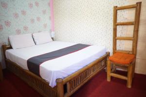 ein Schlafzimmer mit einem Bett, einer Leiter und einem Stuhl in der Unterkunft Collection O 93000 Karona Berg Homestay & Cafe in Banyuwangi
