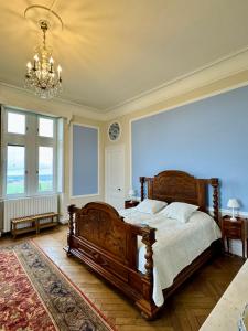 a bedroom with a large wooden bed and a chandelier at Chateau Moncassin in Leyritz-Moncassin
