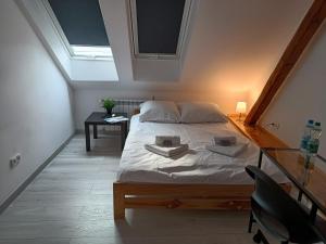 a bedroom with a bed and a desk and a window at Sleep In Center in Kraków