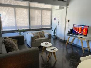 sala de estar con sofá y TV en OM Departamento pleno centro en Mendoza