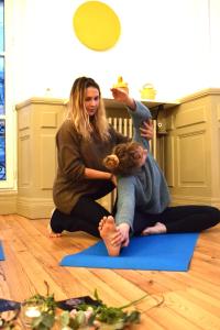 two women sitting on the floor in a yoga class at Hôtel & Espace Bien-être La Maison du Lierre in Biarritz