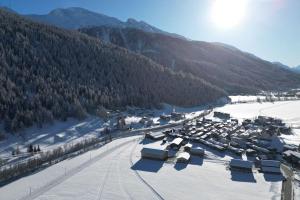 a snow covered mountain with a town in the foreground at Chalet Arrabona - entspannt! in Obergesteln