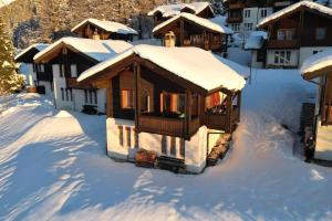 a cabin in the snow with snow covered roofs at Chalet Arrabona - entspannt! in Obergesteln