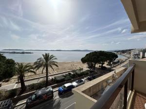 un balcon avec vue sur une plage et des voitures dans l'établissement Appartement 2 pièces Sainte-Maxime proche plage avec parking et climatisation - FR-1-226-533, à Sainte-Maxime
