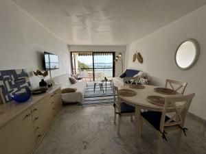 une cuisine et un salon avec une table et des chaises dans l'établissement Appartement 2 pièces Sainte-Maxime proche plage avec parking et climatisation - FR-1-226-533, à Sainte-Maxime