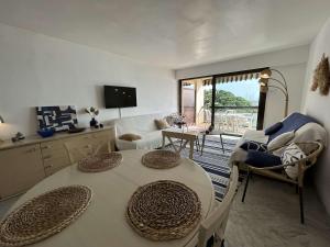 un salon avec une table, des chaises et une télévision dans l'établissement Appartement 2 pièces Sainte-Maxime proche plage avec parking et climatisation - FR-1-226-533, à Sainte-Maxime