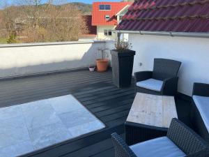 un patio con 2 sillas y una mesa en una terraza en Jenszu Ferienwohnung, en Balingen