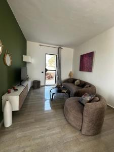 uma sala de estar com dois sofás e uma televisão em Domaine sultana em Awlād ‘Umar