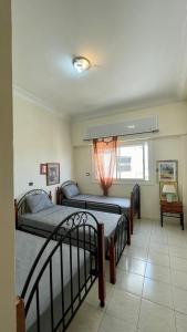 a bedroom with two beds and a window at Elegant and Panoramic 3-Bedroom in Central Tangier in Tangier