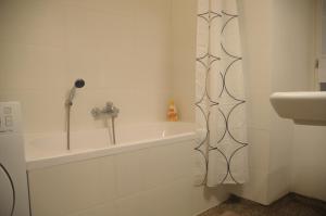 uma casa de banho com um lavatório e uma banheira em Lovely Renovated Apartment Top 11 - Easy Self Check in em Viena