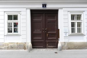 uma porta castanha num edifício branco com duas janelas em Lovely Renovated Apartment Top 11 - Easy Self Check in em Viena