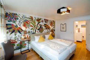ein Schlafzimmer mit einem weißen Bett und einer farbenfrohen Wand in der Unterkunft Ferienwohnung Nemo in Westerland