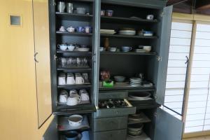 a pantry filled with lots of dishes and bowls at Guesthouse ONE WORLD in Kitsuki