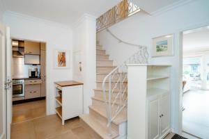 eine Treppe in einem Haus mit weißen Wänden in der Unterkunft Ferienhaus Sprotte in Tinnum