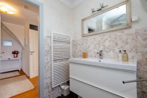 a bathroom with a sink and a mirror at Ferienhaus Sprotte in Tinnum