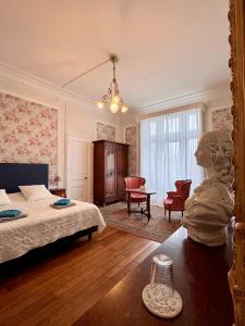 um quarto com uma cama e uma estátua sobre uma mesa em Chateau Moncassin em Leyritz-Moncassin