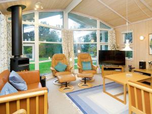 uma sala de estar com duas cadeiras e uma lareira em 10 person holiday home in Gr sted em Udsholt Sand