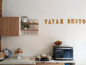 une cuisine avec un four micro-ondes et un panneau indiquant la réponse yaya dans l'établissement Yayah Guest House Syariah by Cocotel, à Bubulak 3