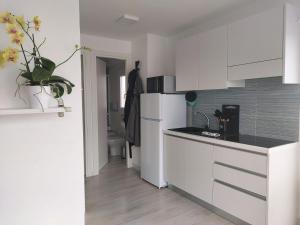 a kitchen with white cabinets and a white refrigerator at Grado Floating Resort in Grado