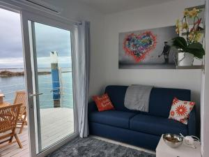 a blue couch in a living room with a sliding glass door at Grado Floating Resort in Grado
