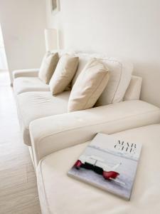 un soggiorno con un divano bianco e un libro sopra di La Via del Castello a Castelferretti