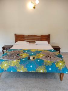 uma cama com um cobertor azul e amarelo em Primavera Holiday Homes em Candolim