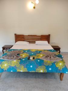 a bed with a blue and yellow blanket on it at Primavera Holiday Homes in Candolim