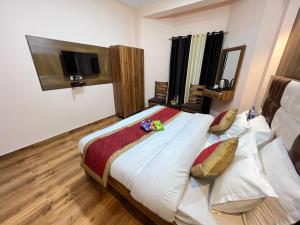 a bedroom with a bed and a television in it at Hotel Canadian forest view in Dalhousie