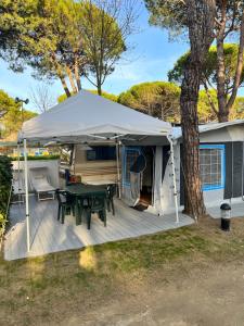 a patio with a table and a tent at Caravan Cavallino - Valentini in Campeggio Union Lido in Cavallino-Treporti