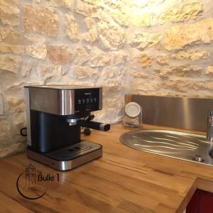 eine Kaffeemaschine auf einer Theke neben einem Waschbecken in der Unterkunft la bulle de Chapaize in Chapaize