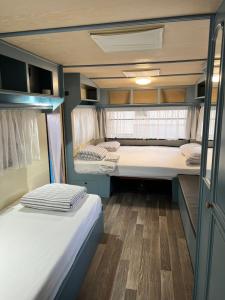 two beds in the back of an rv at Caravan Cavallino - Valentini in Campeggio Union Lido in Cavallino-Treporti