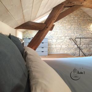 Bett in einem Zimmer mit Ziegelwand in der Unterkunft la bulle de Chapaize in Chapaize
