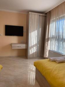 Schlafzimmer mit einem Flachbild-TV und einem Bett in der Unterkunft Luxury Sea Villas - Kabalan in Burgas City