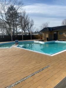 a large swimming pool with a wooden deck at Strandnaher Privat Wohnwagen auf Fehmarn in Fehmarn