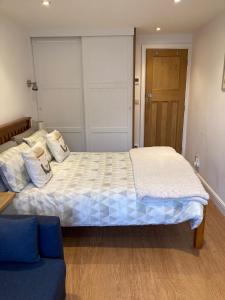 a bedroom with a large bed and a blue couch at Hardy Croft Hideaway in Grassington