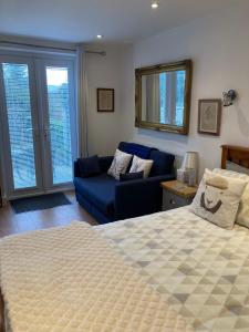 a bedroom with a bed and a blue couch at Hardy Croft Hideaway in Grassington
