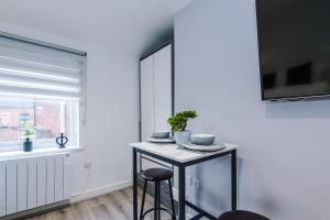 a white room with a table and a window at Modern Studio Apartment in Wigan in Hindley