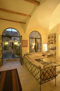 een woonkamer met een groot bed en een groot raam bij Riad Le Palais du Caid. SIecle XVIII in Tozeur