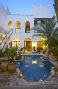 een huis met een zwembad voor een gebouw bij Riad Le Palais du Caid. SIecle XVIII in Tozeur