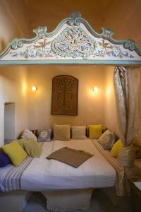 een slaapkamer met een groot bed met een baldakijn bij Riad Le Palais du Caid. SIecle XVIII in Tozeur
