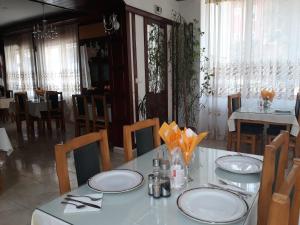 uma sala de jantar com uma mesa branca e cadeiras em Hotel Alice em Băile Olăneşti