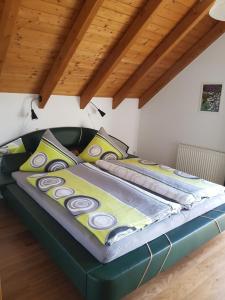 Cama grande en habitación con techo de madera en Gemütliche Ferienwohnung im schönen Erzgebirge - Wohnung Frühling en Eibenstock