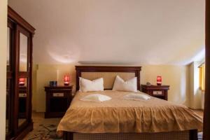 a bedroom with a large bed with two night stands at Hotel Alice in Băile Olăneşti