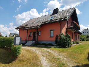 una pequeña casa naranja en un camino de tierra en Gemütliche Ferienwohnung im schönen Erzgebirge - Wohnung Frühling en Eibenstock