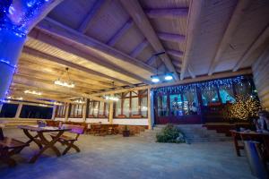 a restaurant with wooden ceilings and tables and chairs at Pensiunea Koronka in Corunca