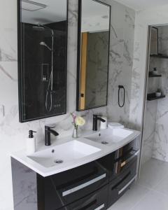 baño con lavabo blanco y 2 espejos en Au bois Noël - LE CHARME, en Lescherolles