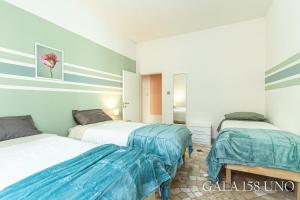 two beds in a room with blue and white walls at Gala158UNO in Bologna